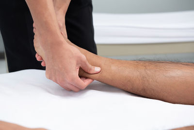 Close-up of healthcare worker massaging man leg