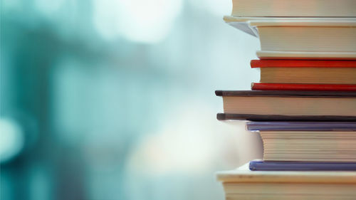 Close-up of books stacked over table