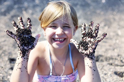 Portrait of smiling girl with arms raised