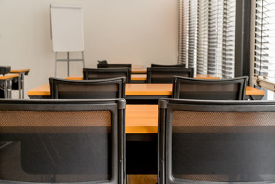 Empty chairs and tables in row