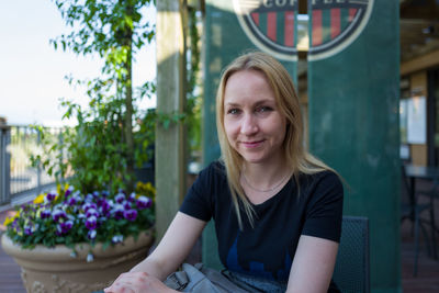 Portrait of smiling woman sitting at sidewalk cafe