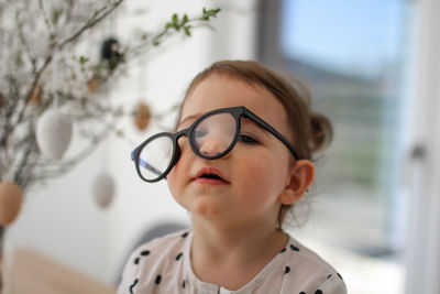 Portrait of young woman wearing eyeglasses at home