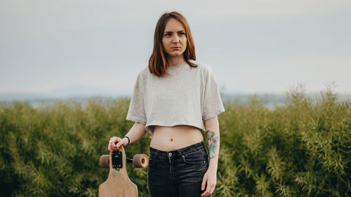 Portrait of young woman standing on field