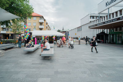 People on street in city against sky