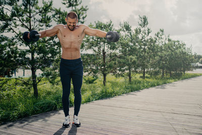 Full length of young man standing on footpath