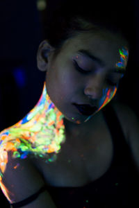 Close-up of young woman with paint on face and shoulder