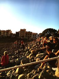 People at beach against clear sky