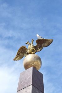 Low angle view of angel statue against sky