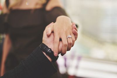 Close-up of bride and groom holding hands