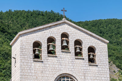 Low angle view of cross on building against sky