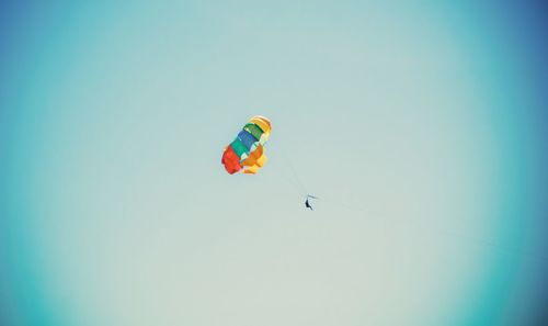 Low angle view of person paragliding against clear sky