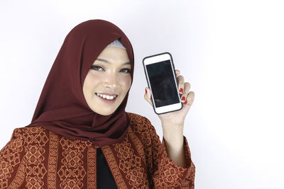 Portrait of smiling young woman using smart phone