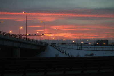 Illuminated bridge against sky at sunset