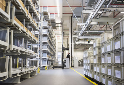 Worker operating forklift in factory warehouse