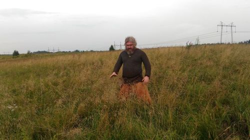 Man standing on field against sky