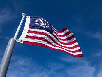 Low angle view of flag against blue sky