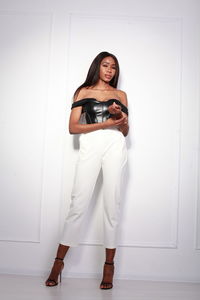 Low section of woman standing against wall