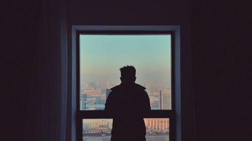 Rear view of silhouette man standing against sky