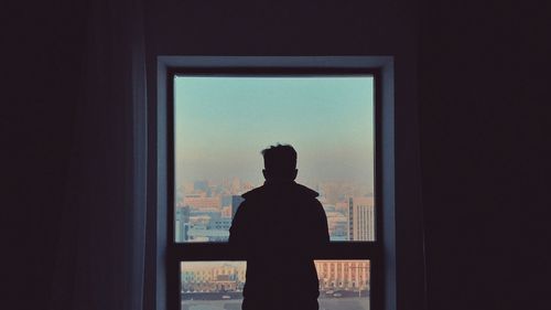 Rear view of silhouette man standing against sky