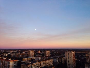 Aerial view of cityscape against blue sky