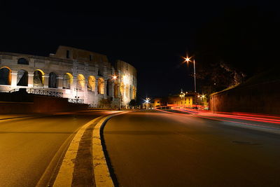 Light trails on road against sky at night