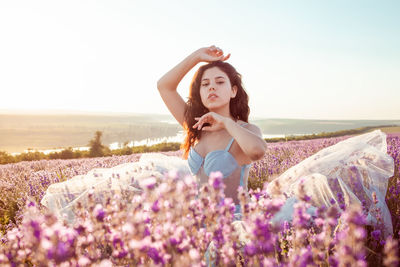 A beautiful young girl against the sunset and a beautiful sky in a lavender field. 