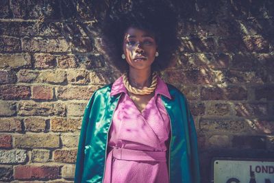 Portrait of woman standing against wall