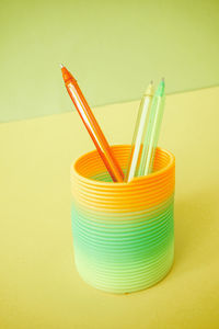 High angle view of multi colored drinking straws against yellow background