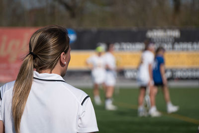 Rear view of women standing against blurred background