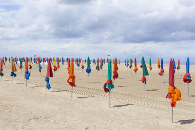 Multi colored umbrellas on beach against sky