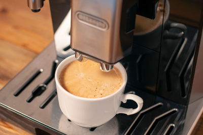 Espresso pouring from coffee machine, close up, professional coffee brewing.