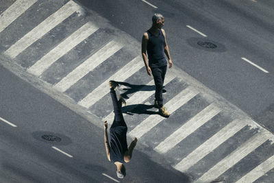 Multiple image of mature man crossing road during sunny day