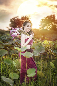 Woman holding umbrella standing on field