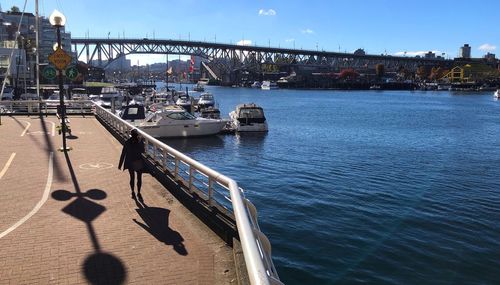 Bridge over river in city against sky