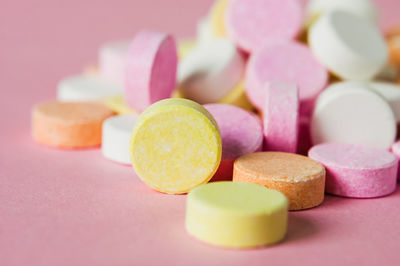 Close-up of multi colored candies over pink background