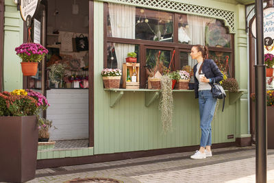 Rear view of young woman standing by window