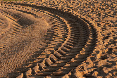 High angle view of tire tracks on sand