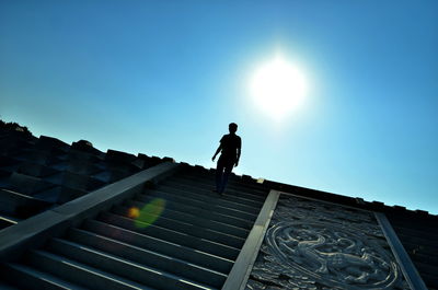 Low angle view of man on steps against sky