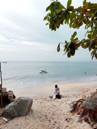 Rear view of people sitting on beach