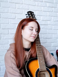 Portrait of young woman playing guitar