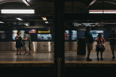 Rear view of people on train at railroad station