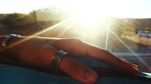 Close-up of hands against sun