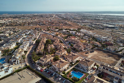 High angle view of city by sea against sky