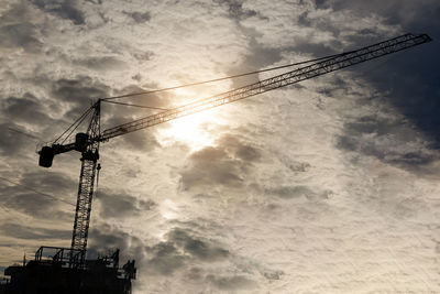 Low angle view of crane against sky