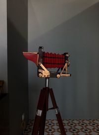 Close-up of coin-operated binoculars on table against wall