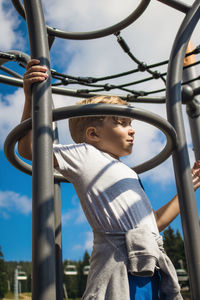 Boy playing at park against sky