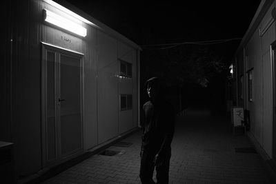 Man standing in illuminated building at night