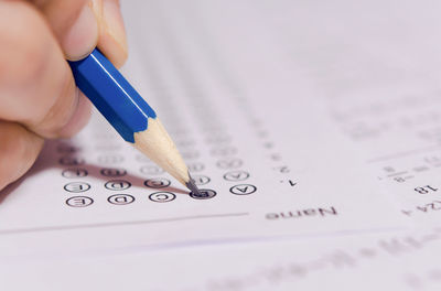 Close-up of hand holding book with text