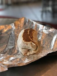 Close-up of wrap sandwich in foil paper on table