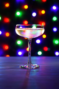 Close-up of drink on table against illuminated lights